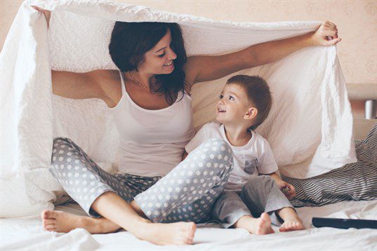 Mother with child underneath a blanket